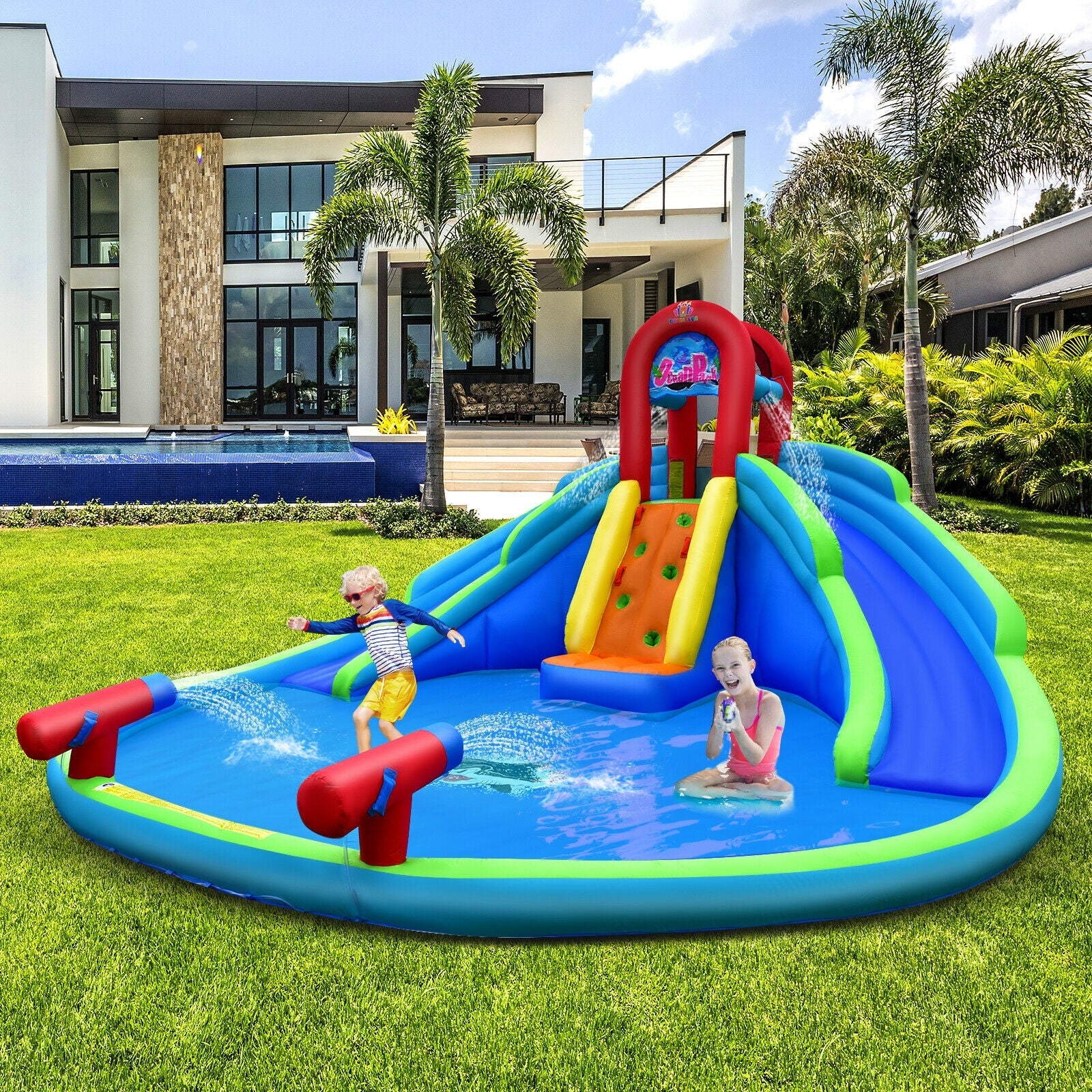 Kids playing on colorful inflatable water slide and bounce house in backyard