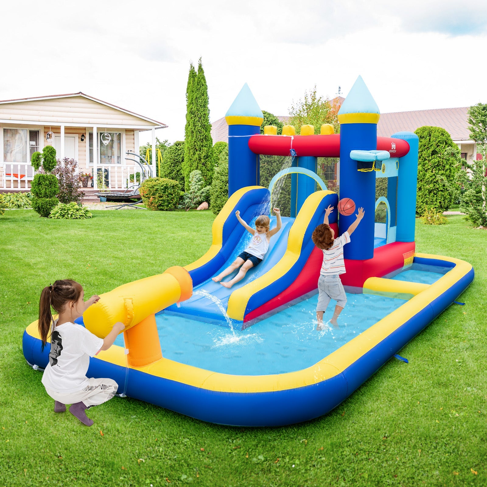 Kids playing on an inflatable water slide bounce house with pool and blower in a backyard