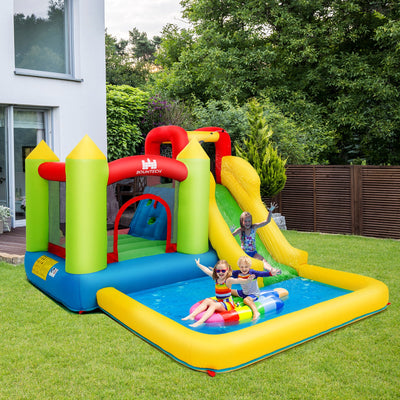 Kids playing on an outdoor inflatable bounce house with water slide and splash pool in backyard