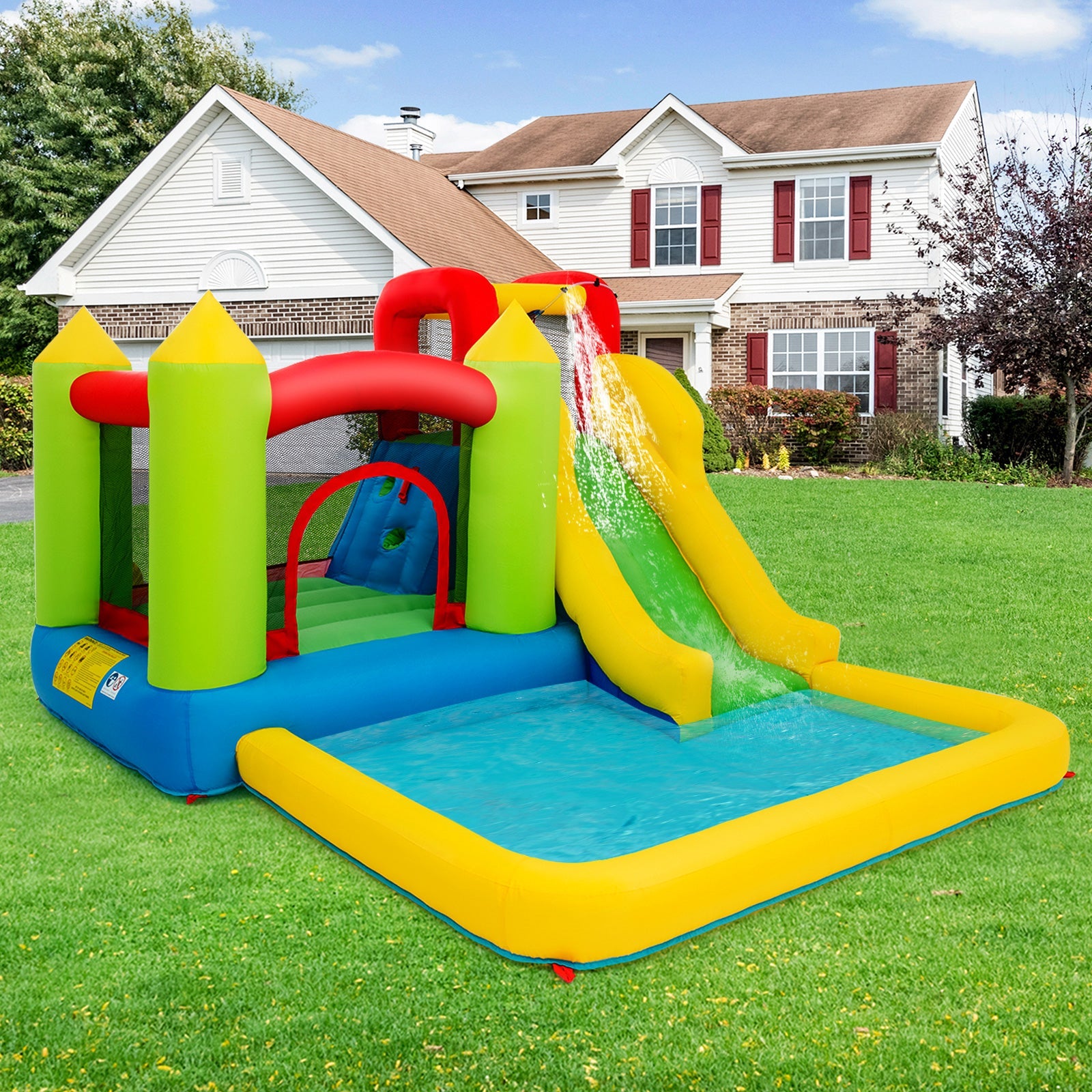Outdoor inflatable bounce house with water slide and splash pool on green lawn